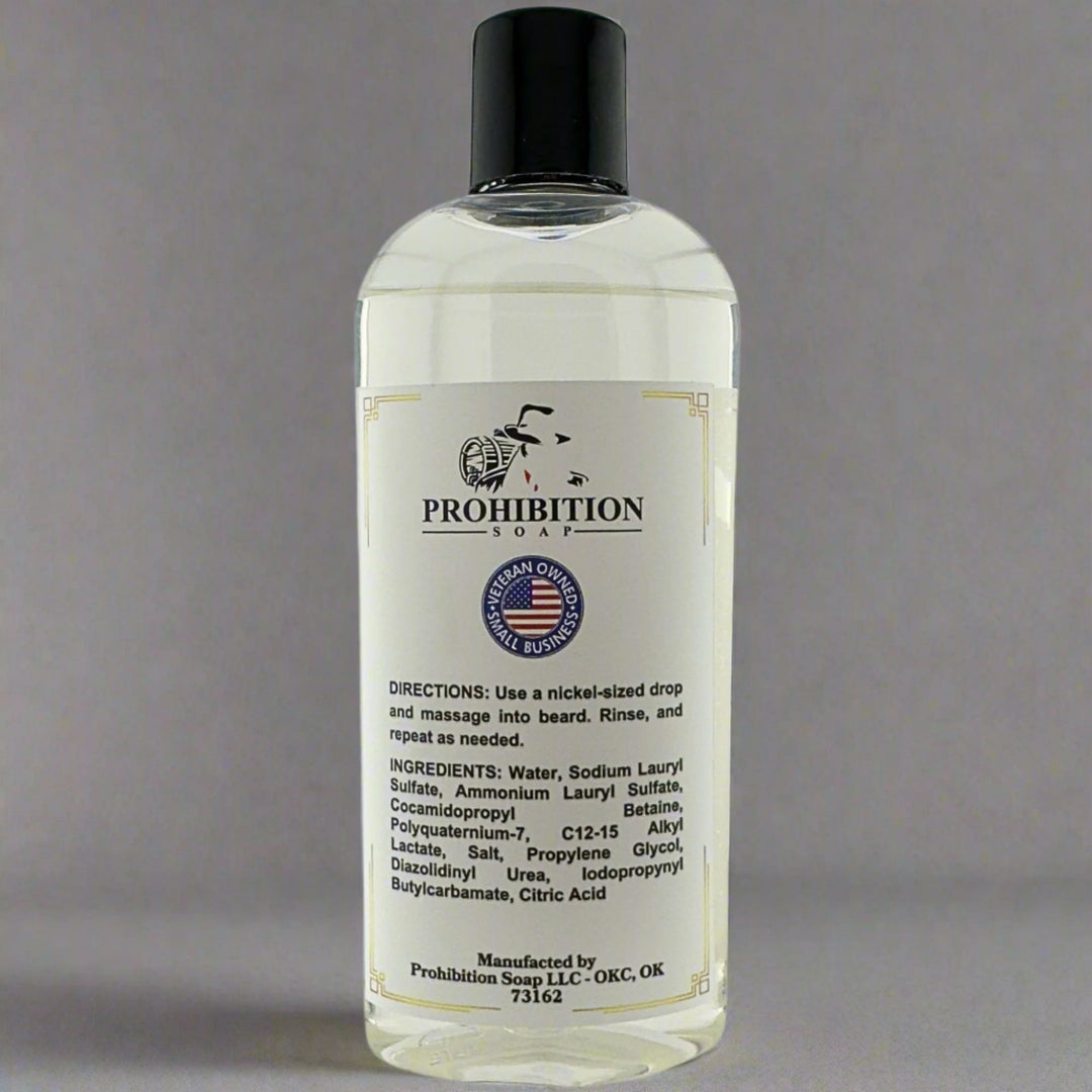 Prohibition Soap Fragrance Free Beard Wash back label showing directions, complete ingredients list including water, sodium lauryl sulfate, and cocamidopropyl betaine, with Veteran Owned Original Business badge on clear bottle containing clear unscented liquid