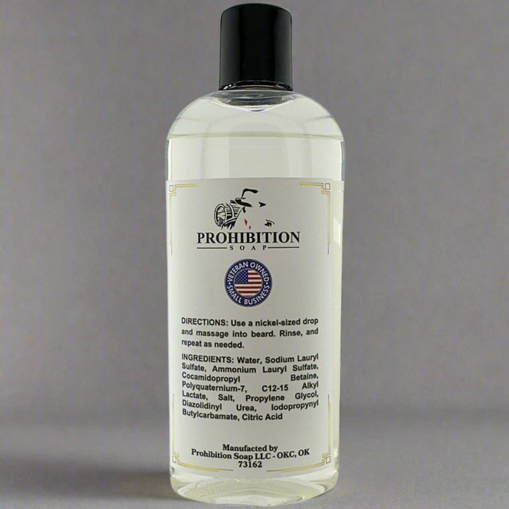 Prohibition Soap Fragrance Free Beard Wash back label showing directions, complete ingredients list including water, sodium lauryl sulfate, and cocamidopropyl betaine, with Veteran Owned Original Business badge on clear bottle containing clear unscented liquid