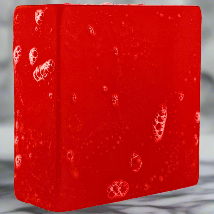 Red soap bar with visible bubbles on a gray background