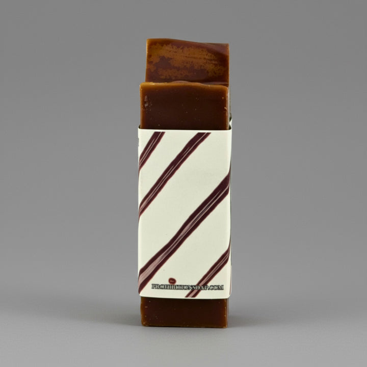 Bar of soap with a striped packaging on a gray background