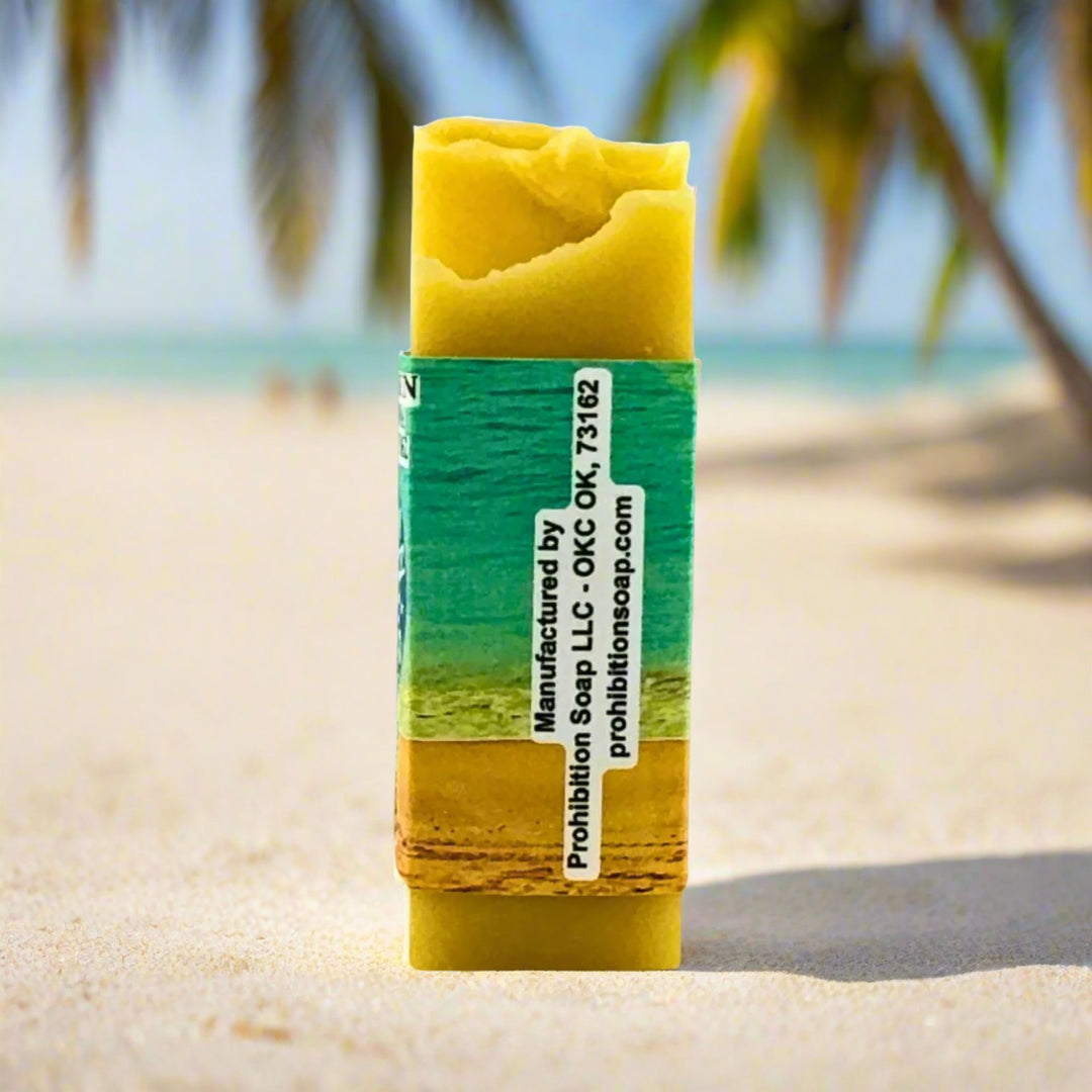 Bar of soap with a green and yellow label on a beach