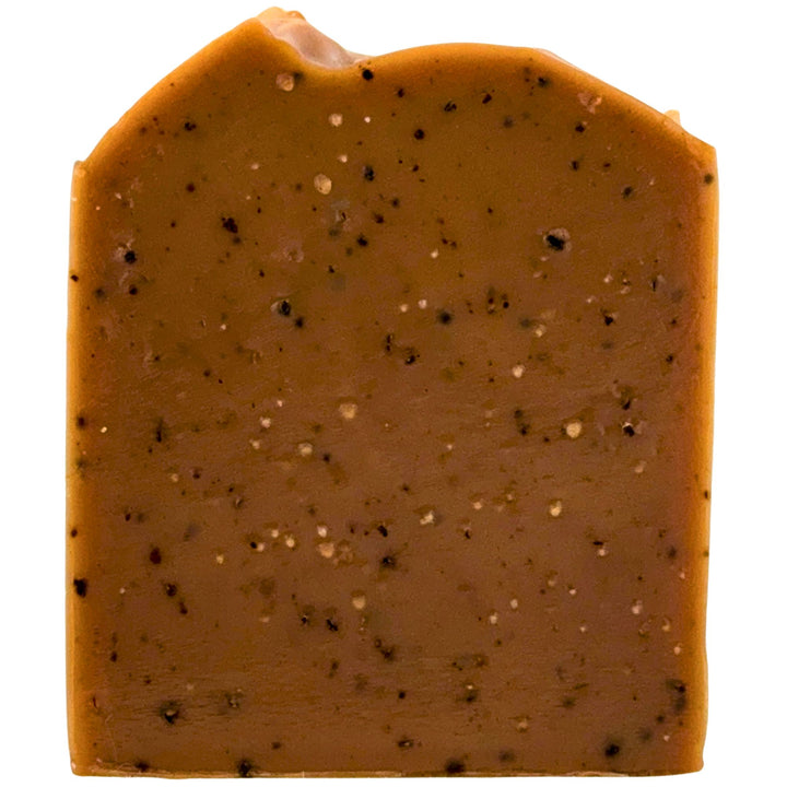 Bare of soap with a brownish-orange color and speckled with coffee grounds on a white background