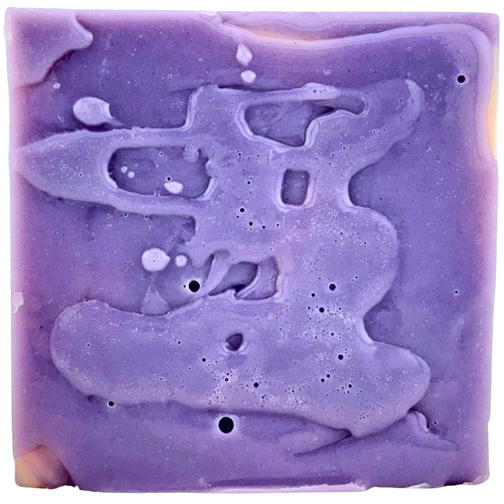 Bar of soap with a purple and white lather on a white background