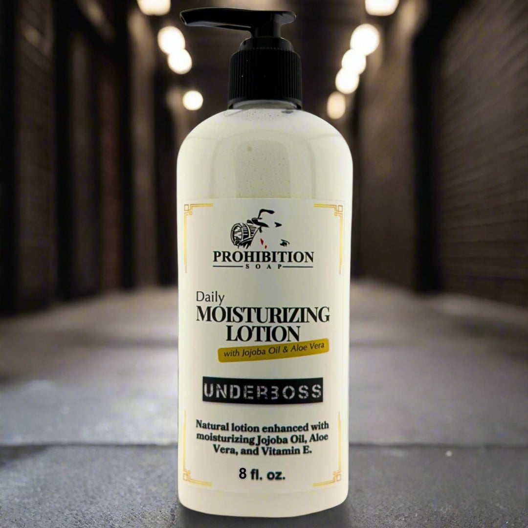 Prohibition Soap Daily Moisturizing Lotion in Underboss scent with 8 fl oz pump bottle on concrete surface with dramatic warm bokeh lighting in background, showing sophisticated cedarwood, tobacco and bourbon fragrance with jojoba oil, aloe vera and vitamin E