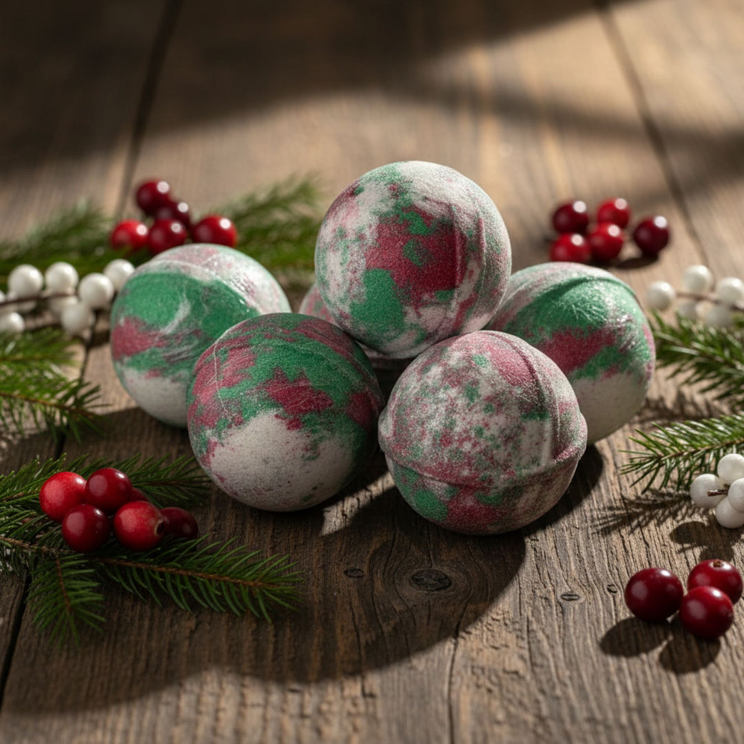 Bath bombs with green and red patterns on a wooden surface with berries and pine branches.