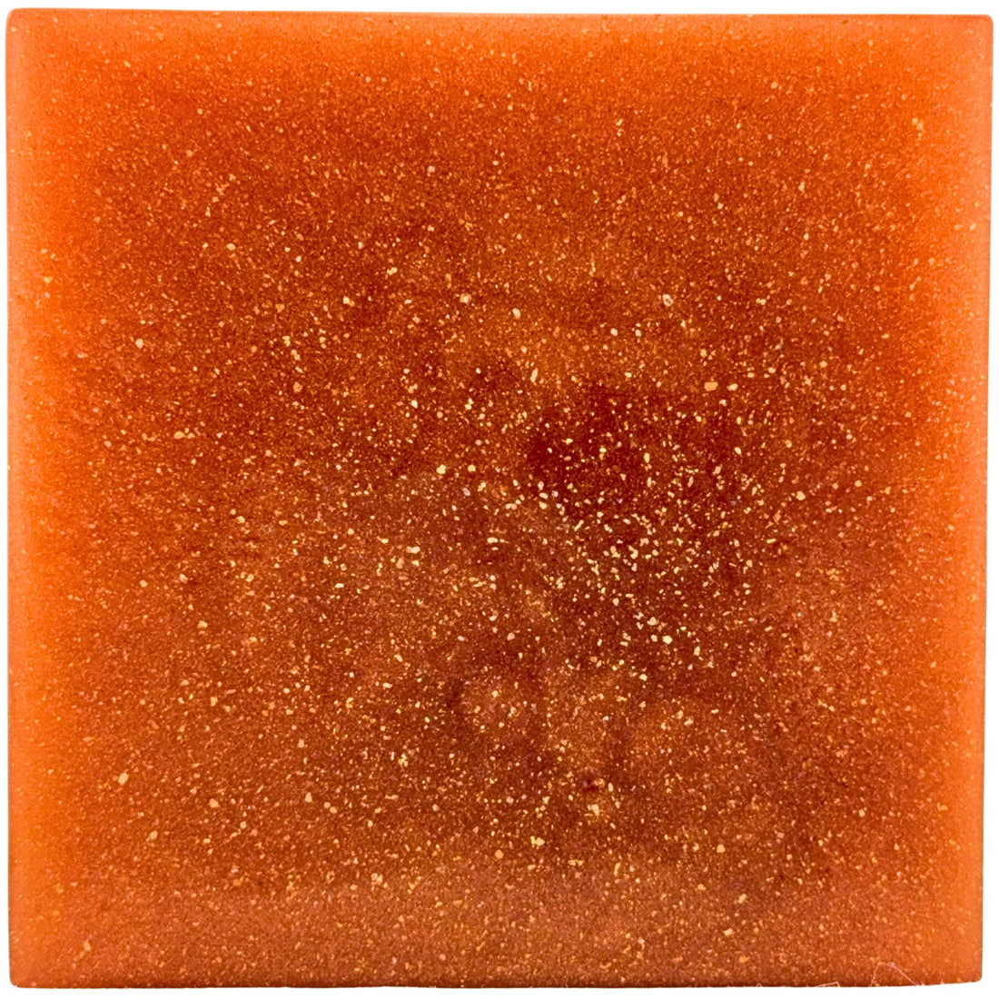 Square piece of orange soap with a sparkly surface