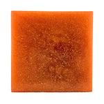 Square piece of orange soap on a white background