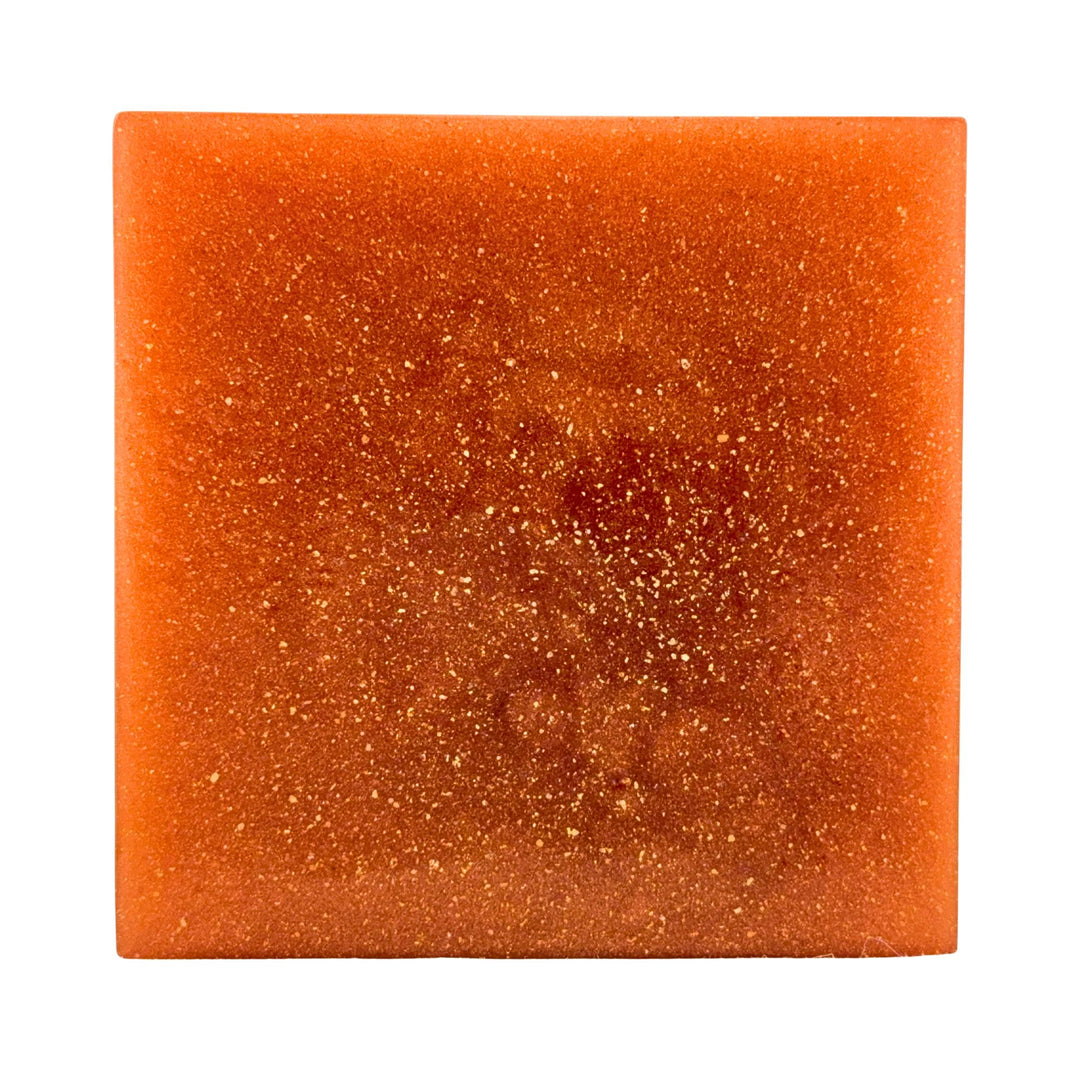 Square piece of orange soap on a white background