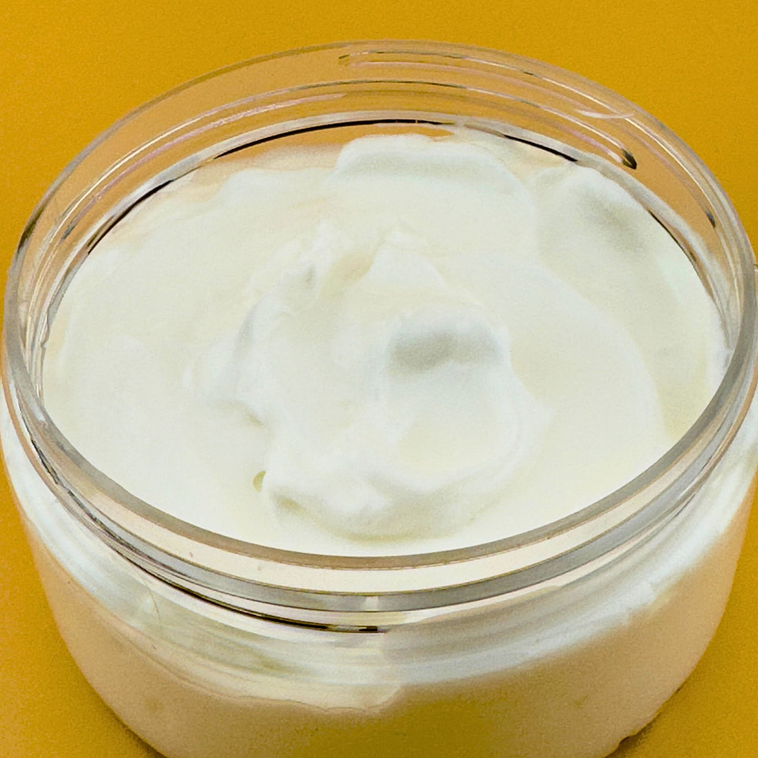 Prohibition Soap Daily Body Cream open jar showing thick, creamy white texture of natural yogurt-based formula with jojoba oil and aloe vera, photographed on golden yellow background