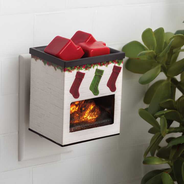 Wall-mounted electric fireplace fragrance warmer with Christmas stockings design and red wax melts on a white wall.