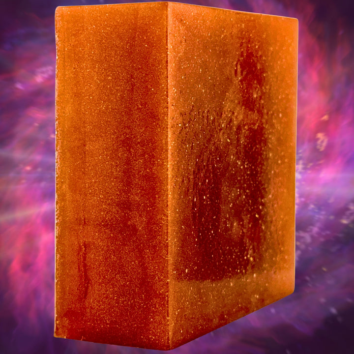 Orange soap with a textured surface against a purple and pink gradient background