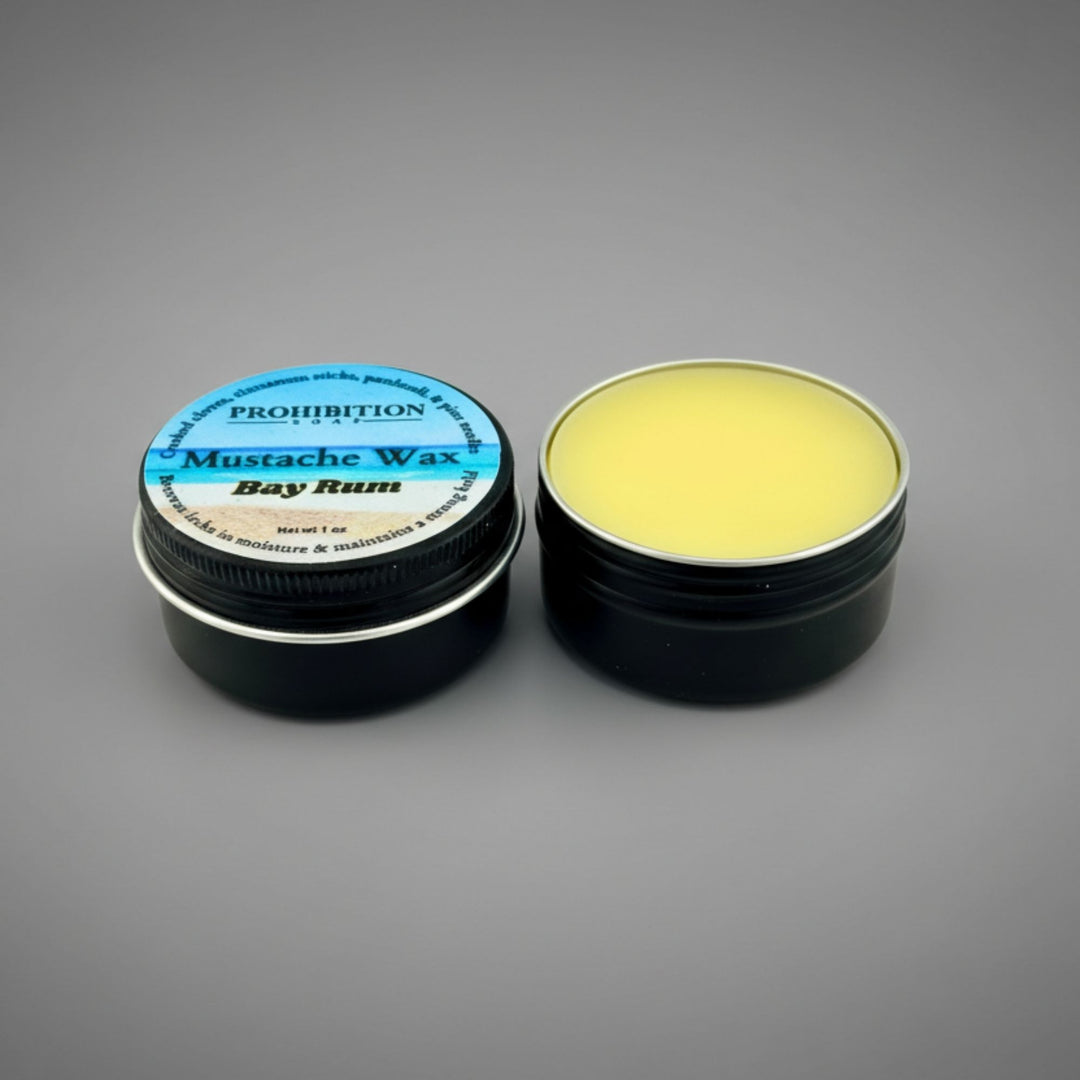 Mustache wax container with lid open on a gray background