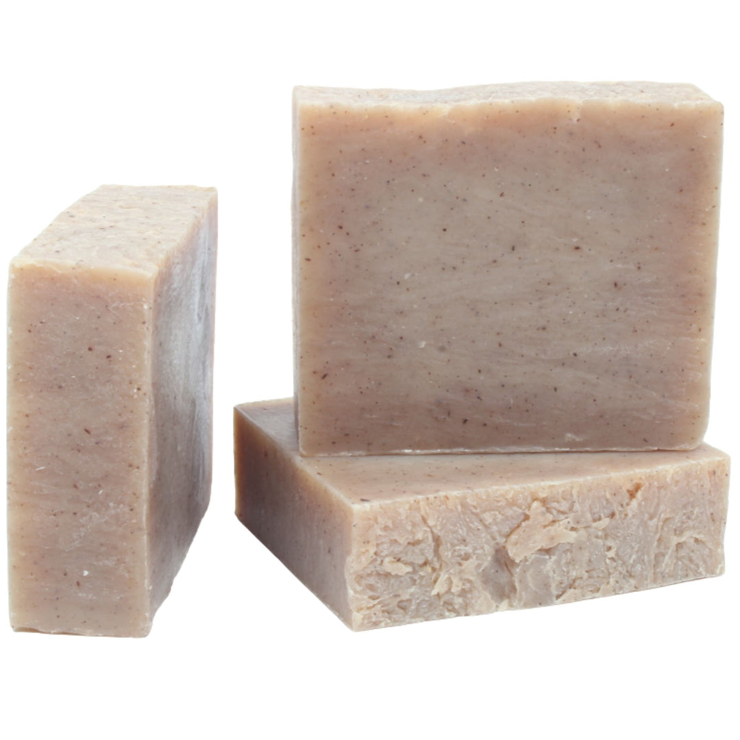 Three bars of beige soap on a white background