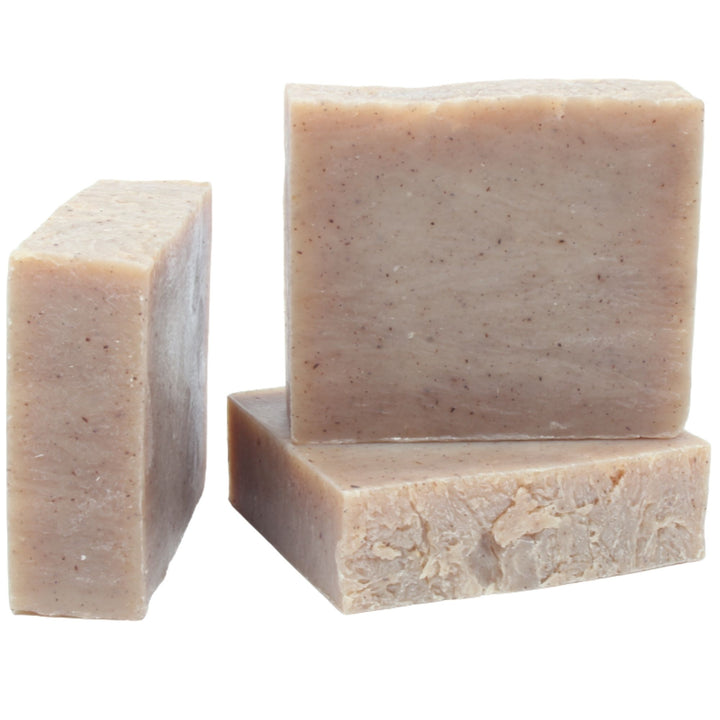 Three bars of beige soap on a white background