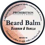 A round tin of Prohibition Soap Beard Balm in the Bourbon & Vanilla scent, featuring a white label with black text and a textured brown and beige graphic on the left side.