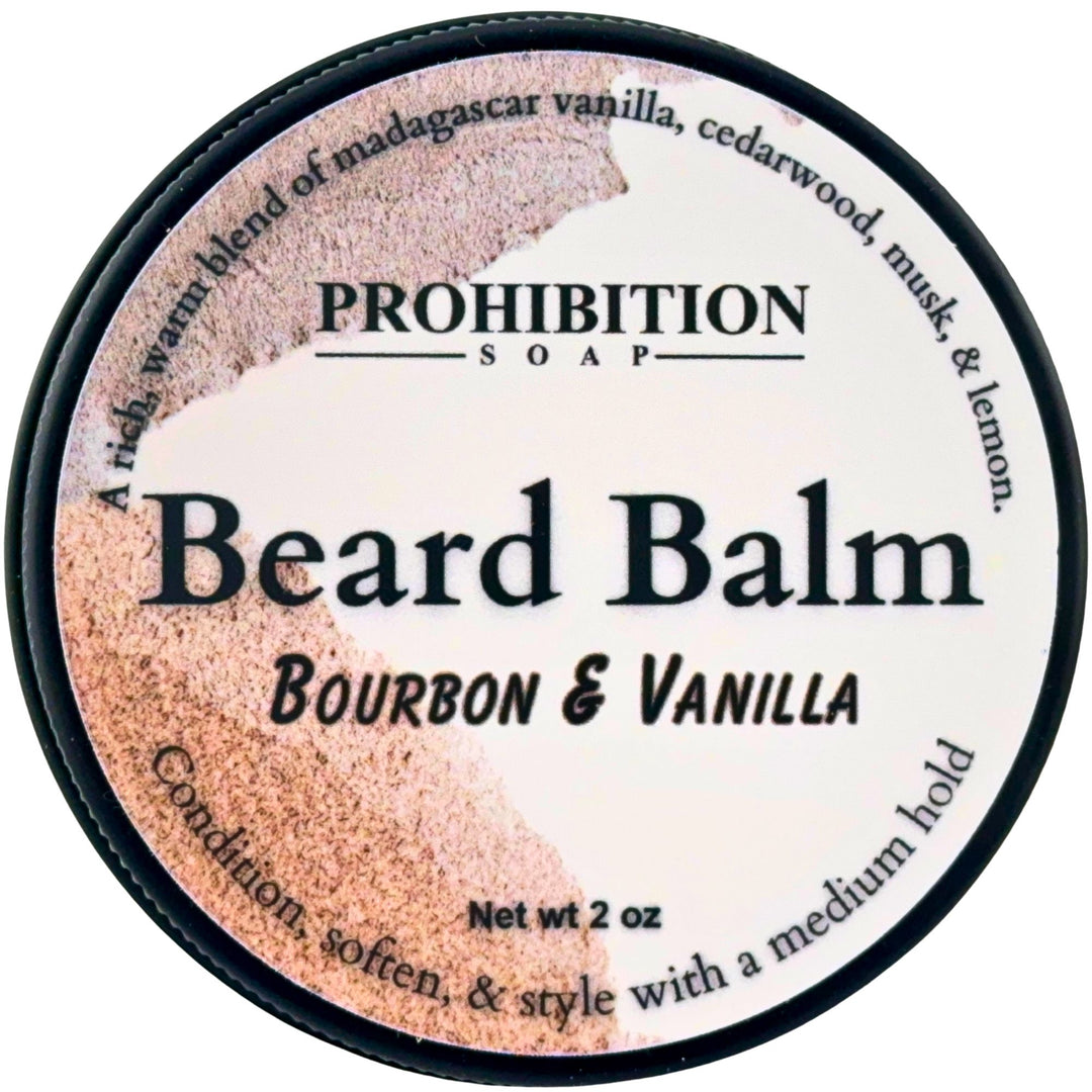 A round tin of Prohibition Soap Beard Balm in the Bourbon & Vanilla scent, featuring a white label with black text and a textured brown and beige graphic on the left side.