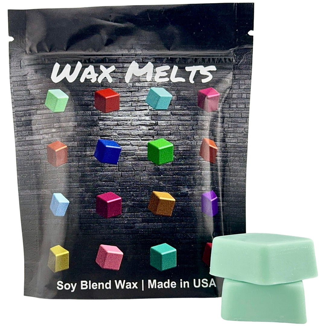 Packaging of wax melts with colorful wax cubes and a single green wax melt outside the packaging.