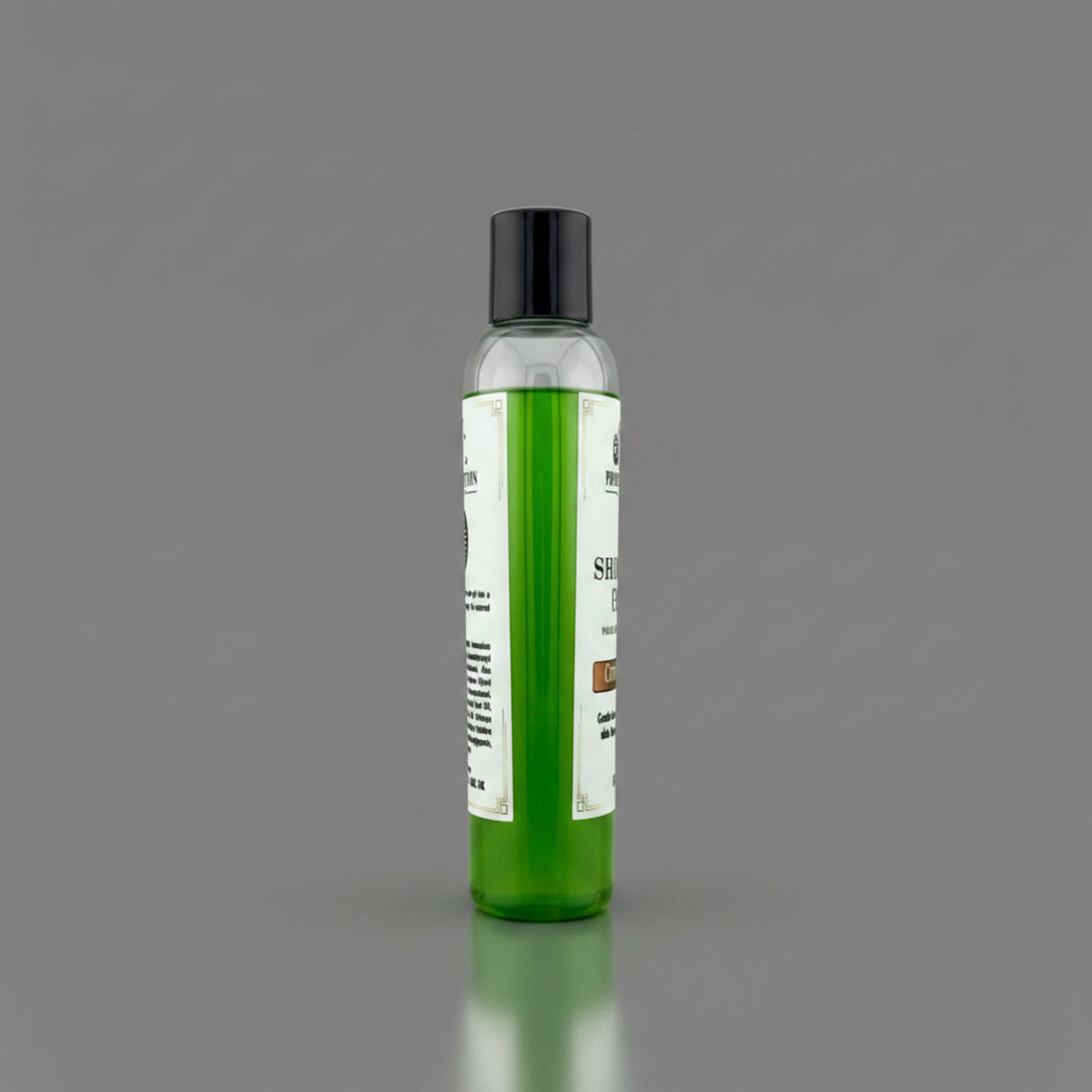 A clear plastic bottle filled with bright green gel, featuring a black cap and a white label, standing upright on a reflective gray surface against a solid gray background.