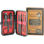 Grooming kit with scissors, clippers, and tweezers in a red case with a cardboard box labeled 'Trixie & Milo' on a white background.