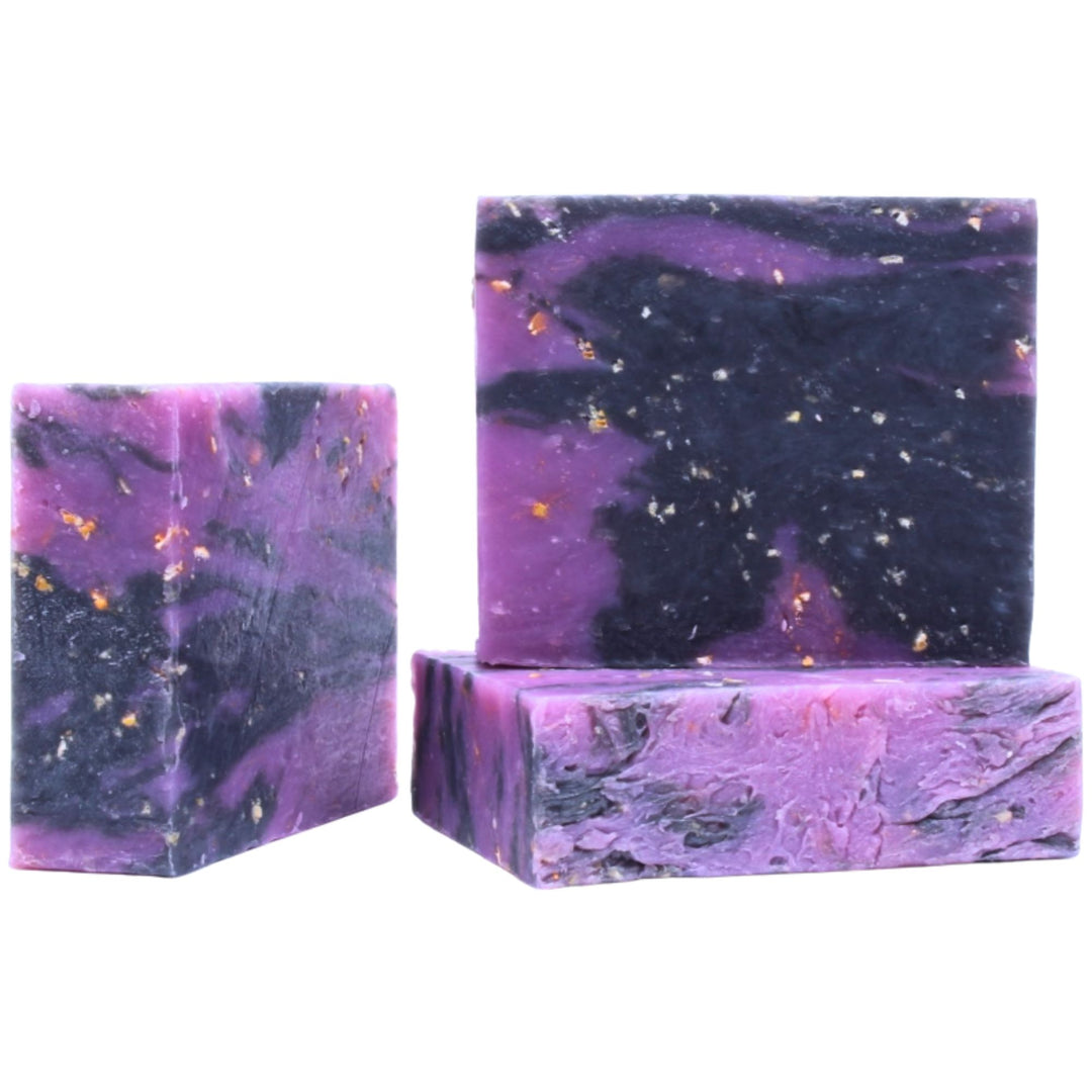 Three purple and black marbled soap bars on a white background