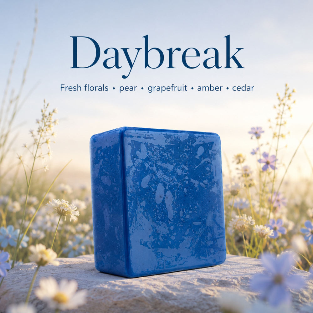 Blue soap bar with 'Daybreak' fragrance description against a natural background