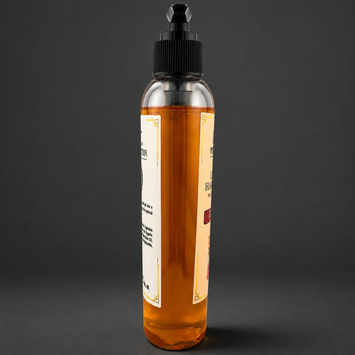 A clear plastic bottle filled with amber-colored soap, featuring a black dropper-style cap and cream-colored labels, set against a dark gray background.