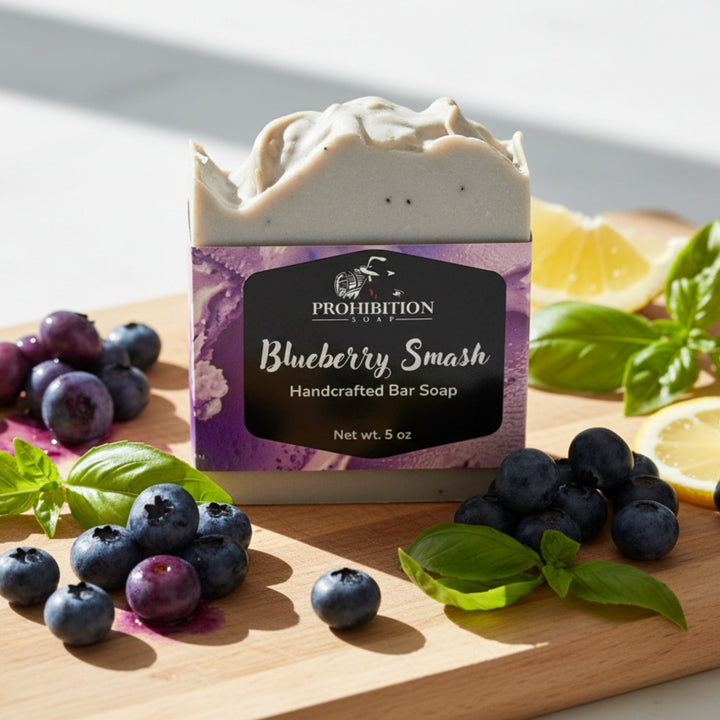 Prohibition Blueberry Smash handcrafted bar soap on a wooden board with blueberries and mint leaves.
