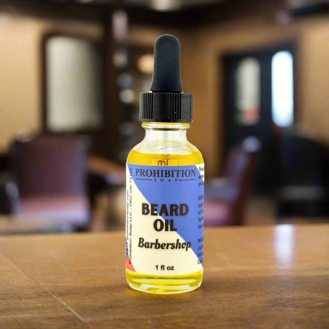 Bottle of Prohibition Soap Beard Oil on a wooden surface with a blurred barbershop background.
