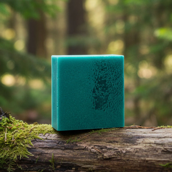 Teal soap on a log with a forest background