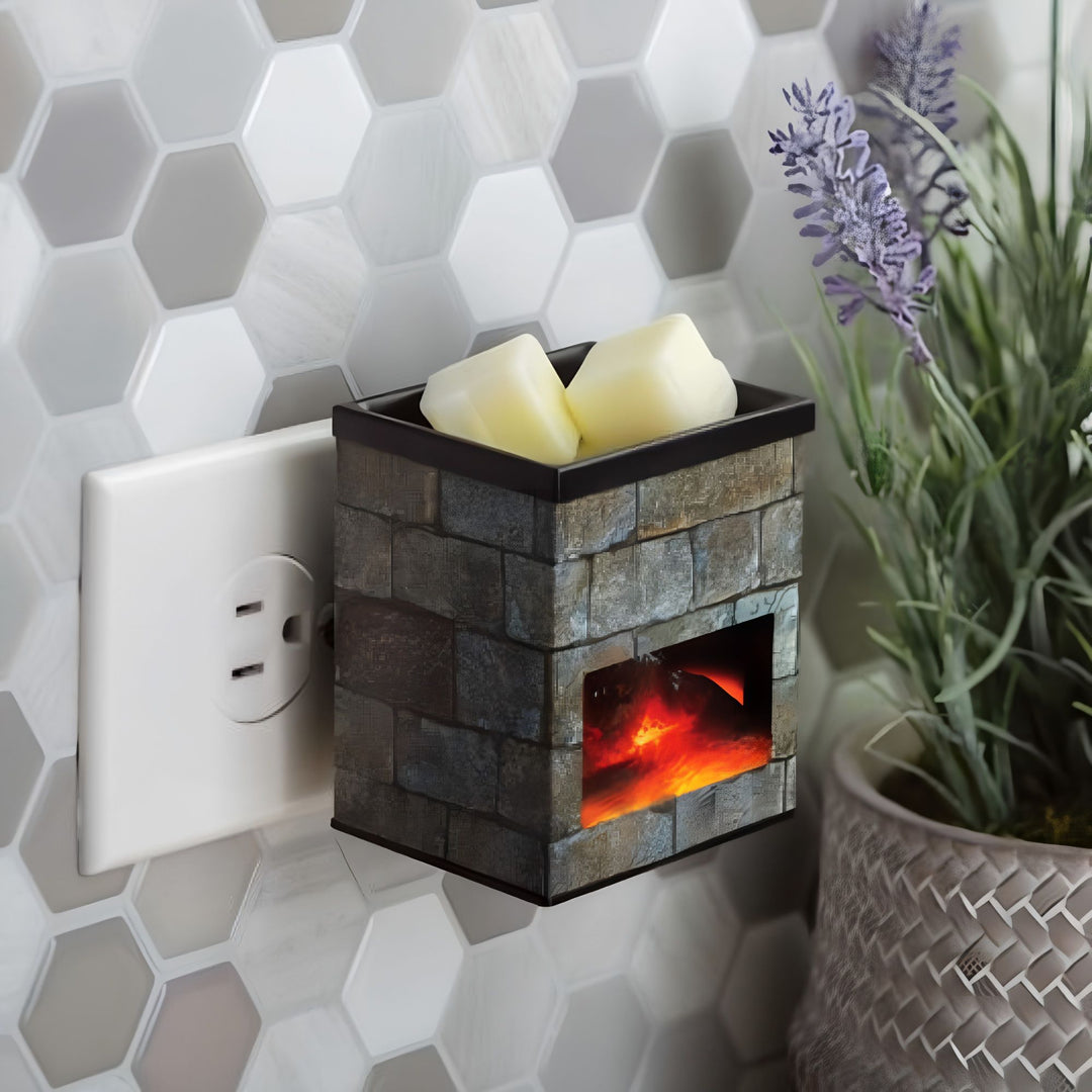 Wall-mounted stone-textured electric fireplace fragrance warmer with wax melts next to a potted plant on a hexagonal tiled wall.