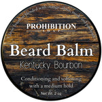 Circular container of Kentucky Bourbon Beard Balm with a wooden background design. The brand 'Prohibition Soap' is displayed at the top and the product name 'Beard Balm' is repeated along with 'Kentucky Bourbon' and a description.