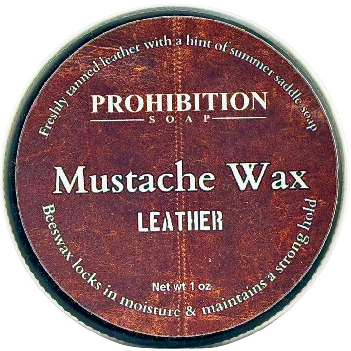 A round metal tin of Prohibition Soap Mustache Wax in the Leather scent, showing the textured brown label on a white background.