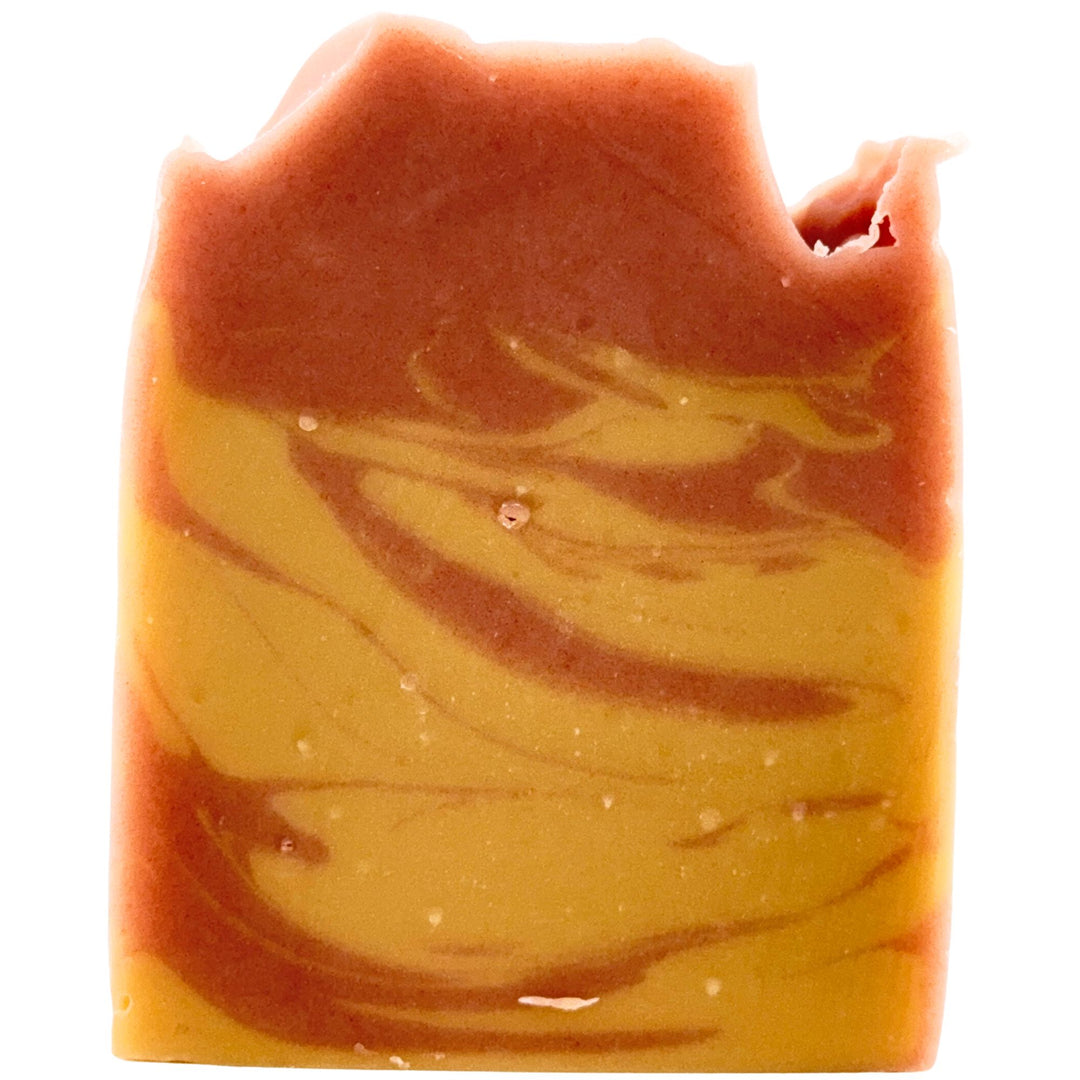A rectangular bar of marbled artisan soap with a swirled pattern of warm orange-brown and golden yellow, isolated on a white background.
