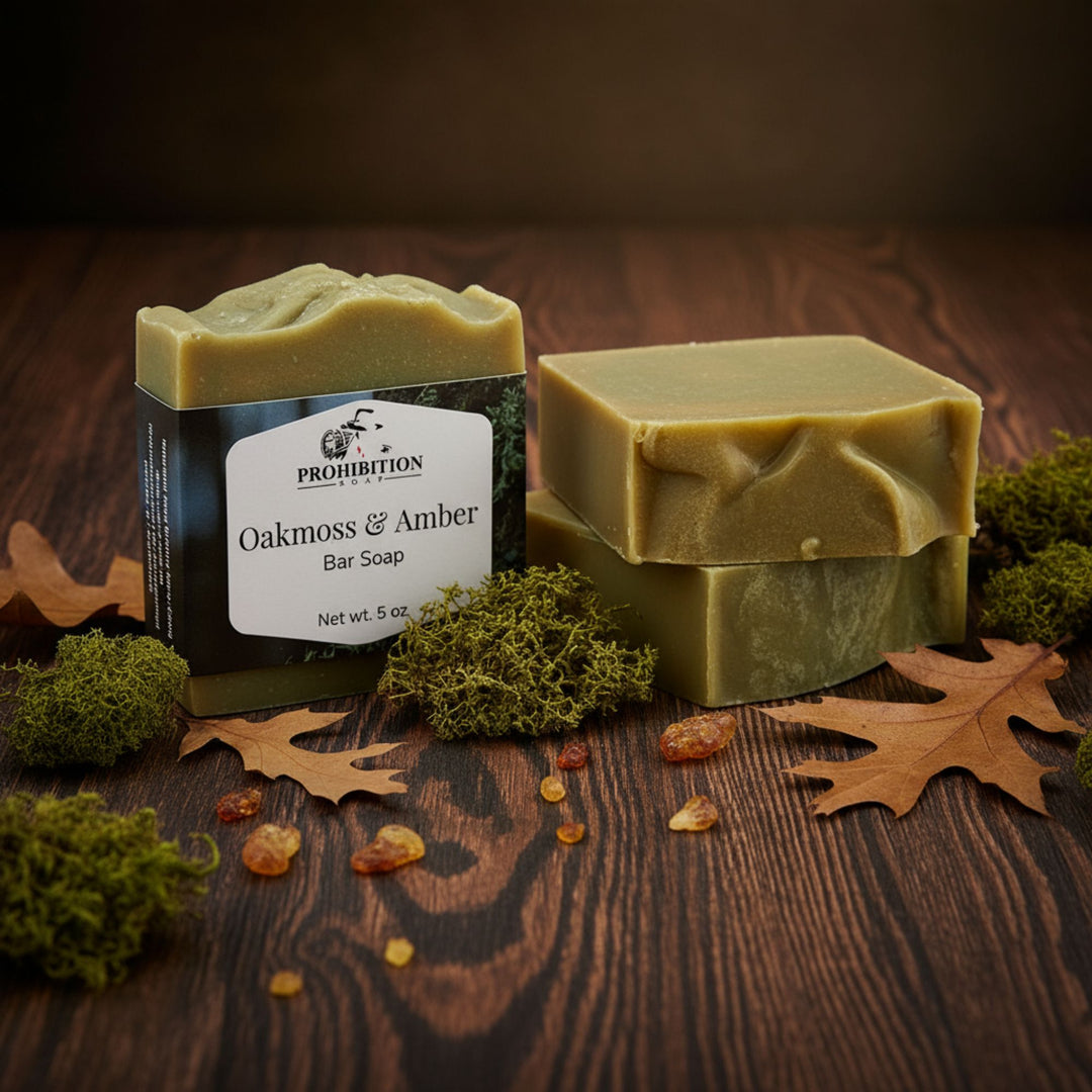 Three bars of soap, one with packaging, on a wooden surface with natural elements.