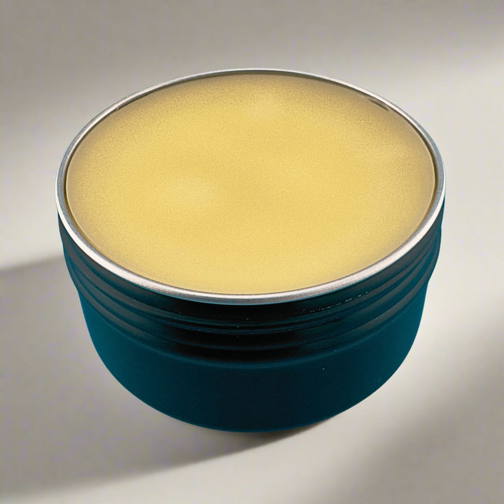 Round container with a metallic lid on a neutral background
