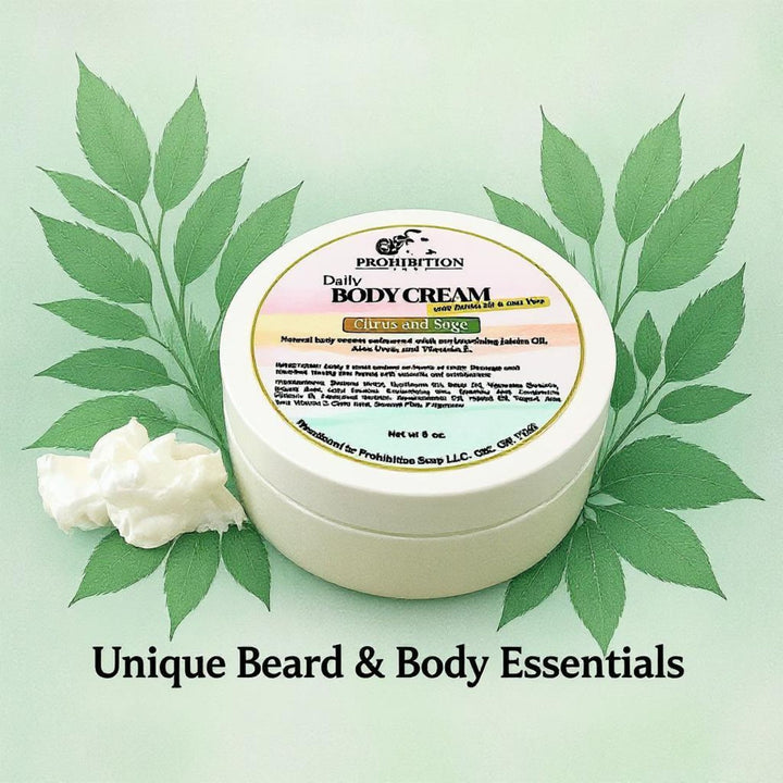 Prohibition Soap Daily Body Cream with Citrus and Sage scent surrounded by natural green leaves and cream dollop on soft green background with 'Unique Beard & Body Essentials' tagline, showcasing natural yogurt-based formula