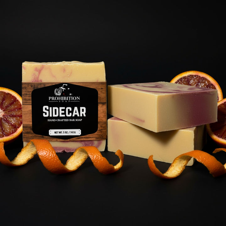 Prohibition Sidecar soap with blood orange slices and peels on a black background