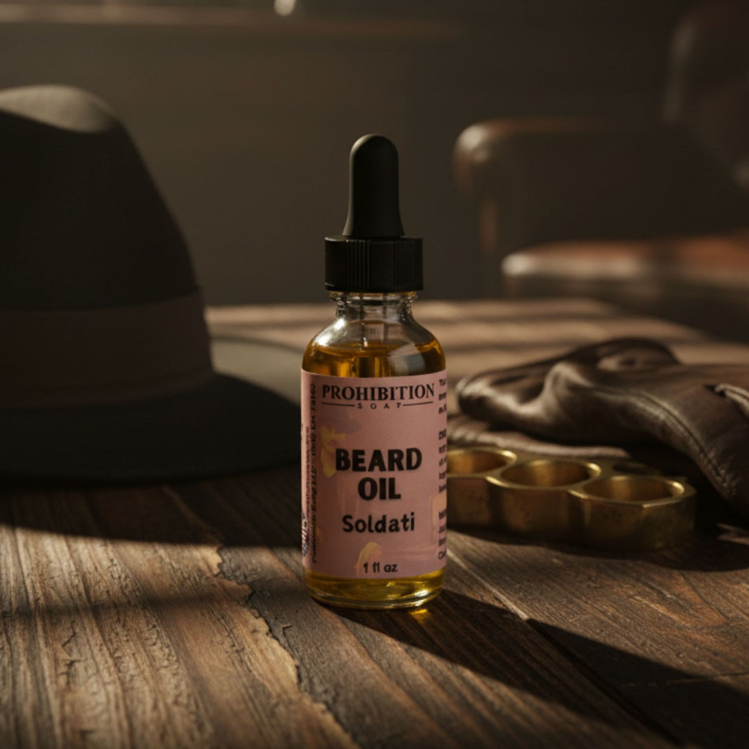 Bottle of Prohibition Soap Co. beard oil on a wooden surface with a hat and leather goods in the background.