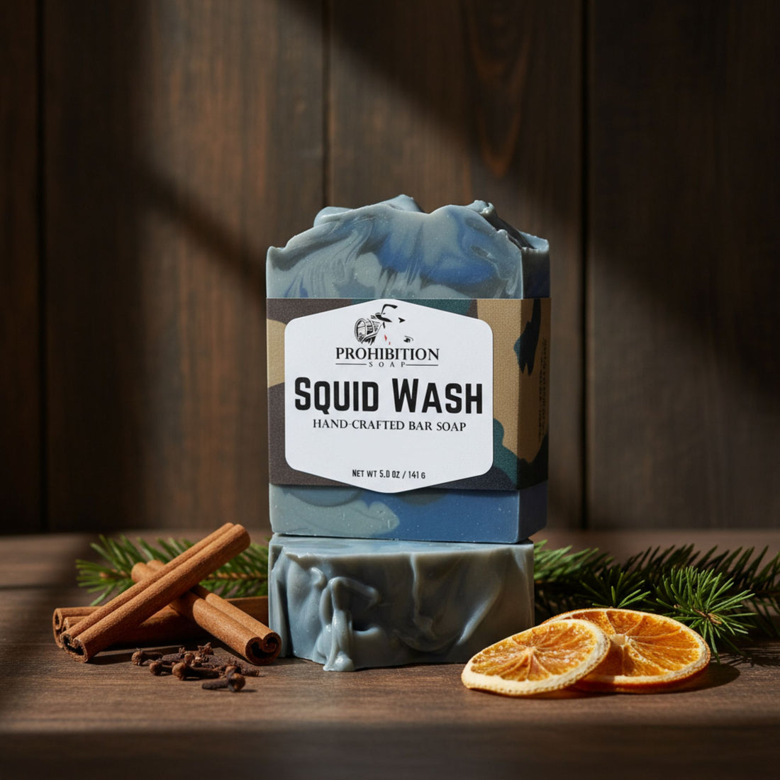 Hand-crafted bar soap with 'Prohibition' branding on a wooden surface with cinnamon sticks and oranges.