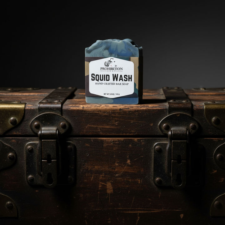 Bar of soap labeled 'Squid Wash' on a wooden chest with a dark background