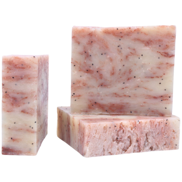 Three bars of pink and white speckled soap on a white background
