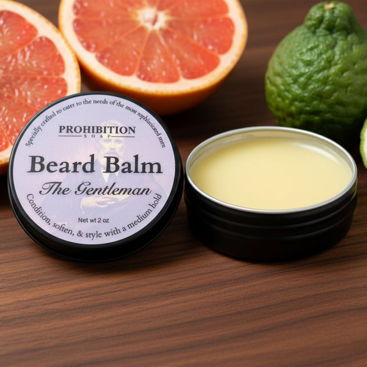 Beard balm container with open lid on a wooden surface with citrus fruits.