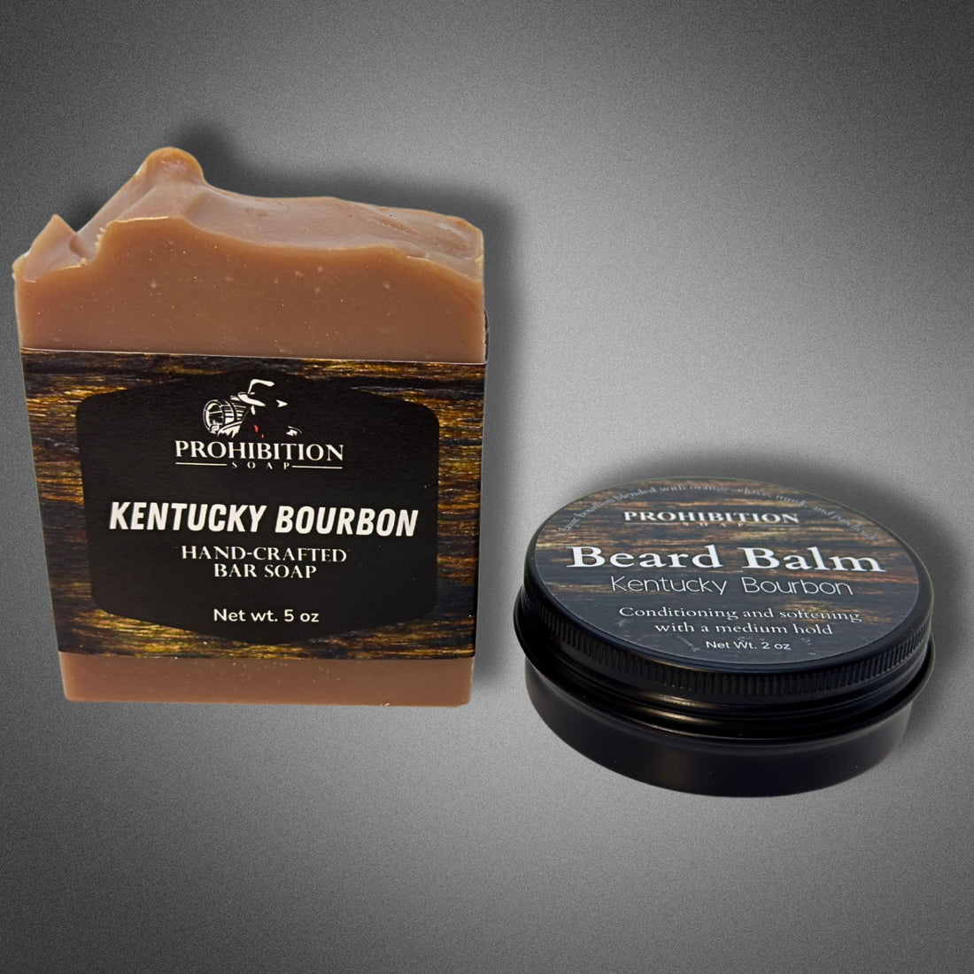 Kentucky Bourbon bar soap beside a tin of Prohibition Soap Kentucky Bourbon Beard Balm on a gray background